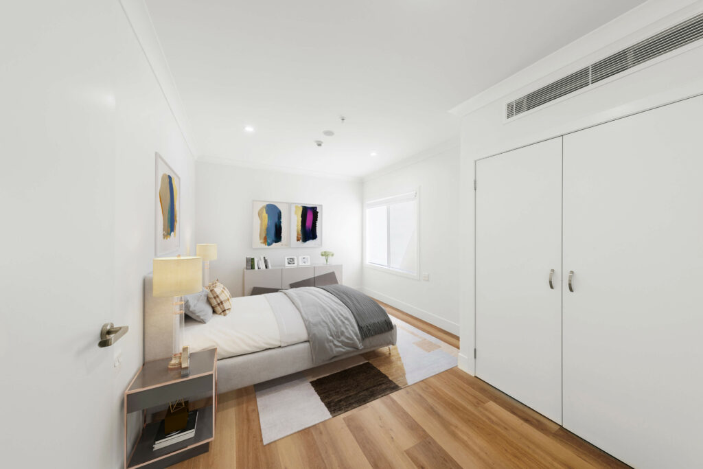 A minimalist bedroom in Maroubra with a single bed, nightstand, rug, and wall art. The room features a large window, light wood flooring, and a white double-door closet.