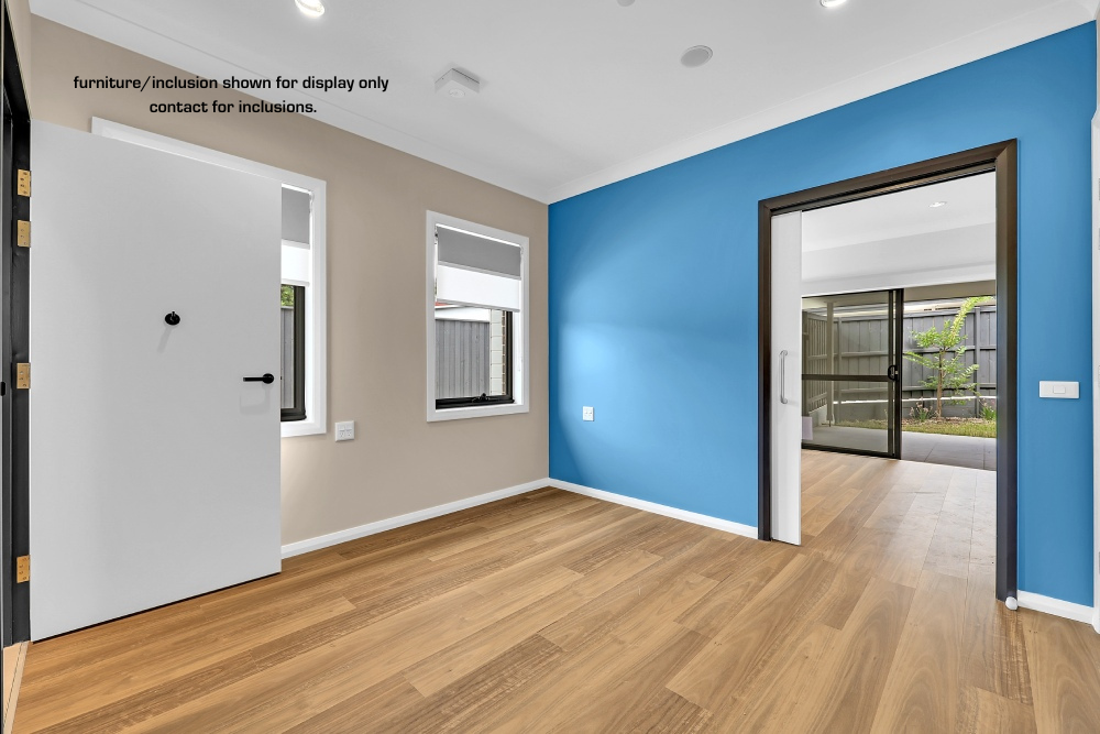 Empty room with light wood flooring, beige and blue walls, two windows, an open white door, and a sliding door leading to another room with glass doors in Concord, Inner West Sydney.