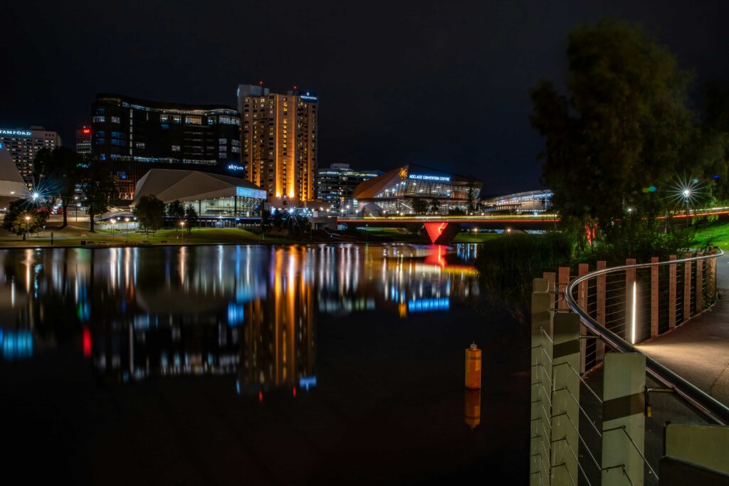 A city at night with a river in the background offers a serene setting.