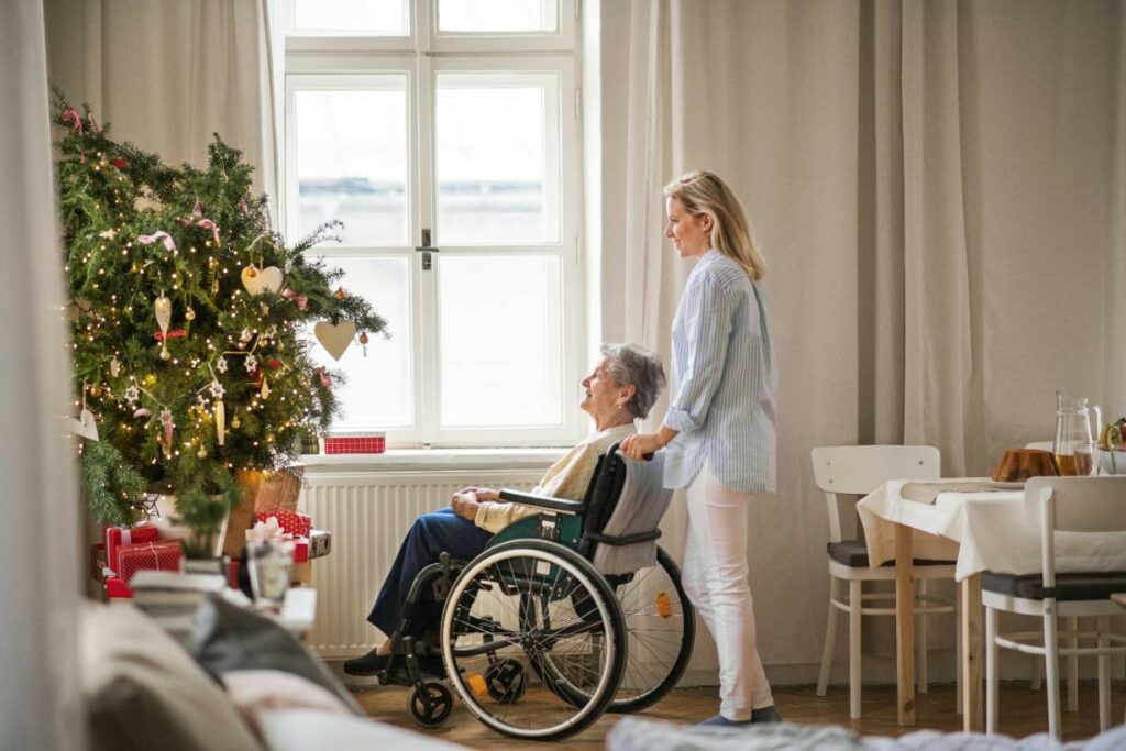 Old lady with her caregiver enjoying Christmas