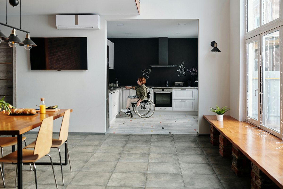 Woman in wheelchair cooking in an accessible kitchen showing independence in cerebral palsy housing Sydney