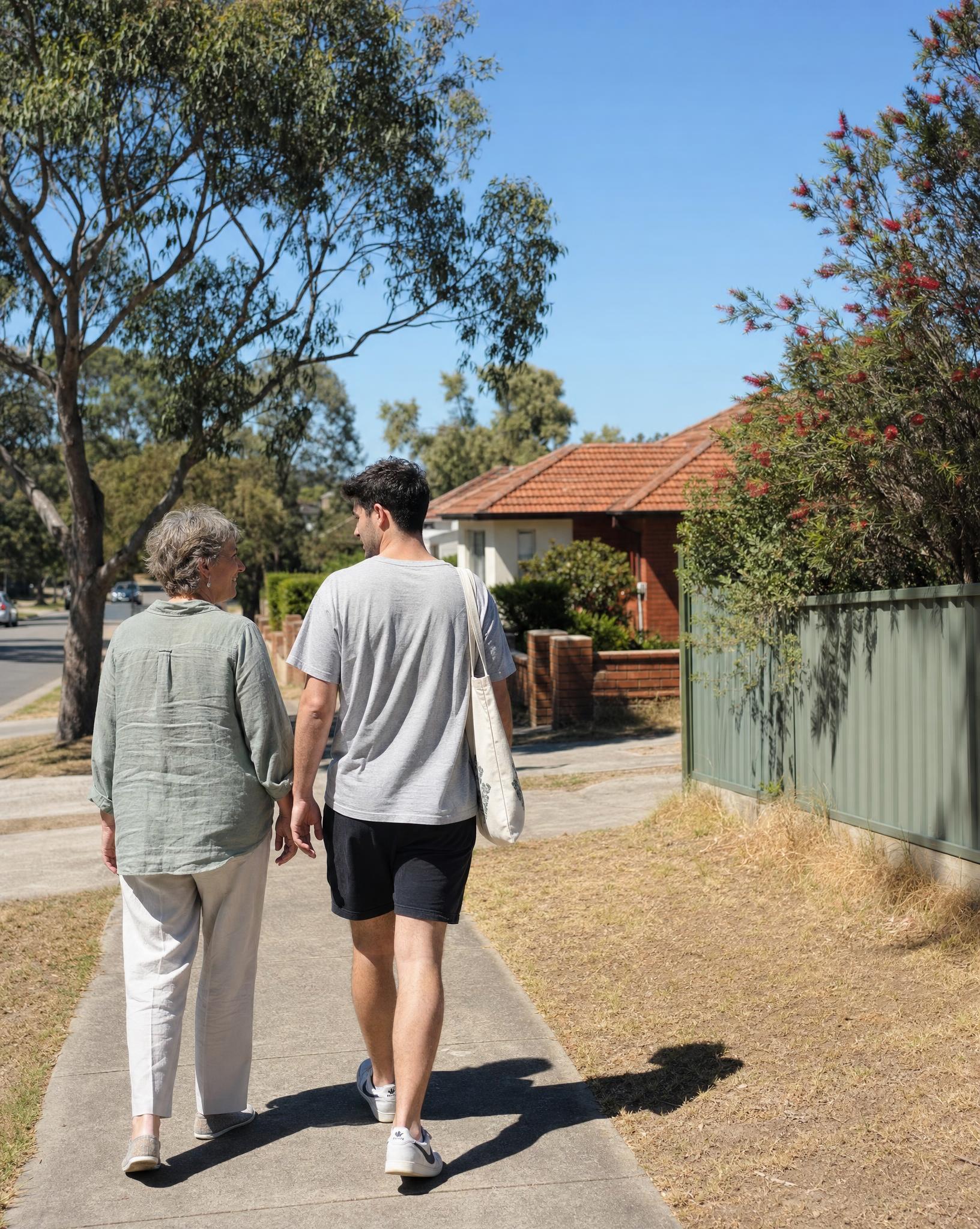 A parent and her adult son walking together in an established Sydney suburb near their SDA home