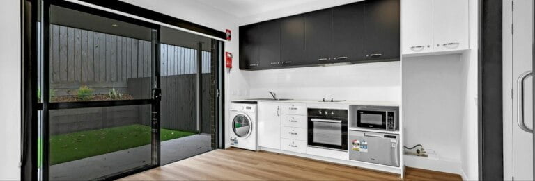 An Auto Draft of a black and white photo featuring a kitchen with a washer and dryer.