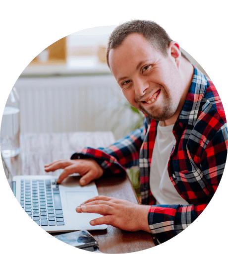 A man sitting at a table with a laptop.