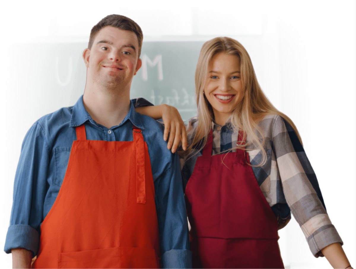 A man and woman in aprons posing for a photo.