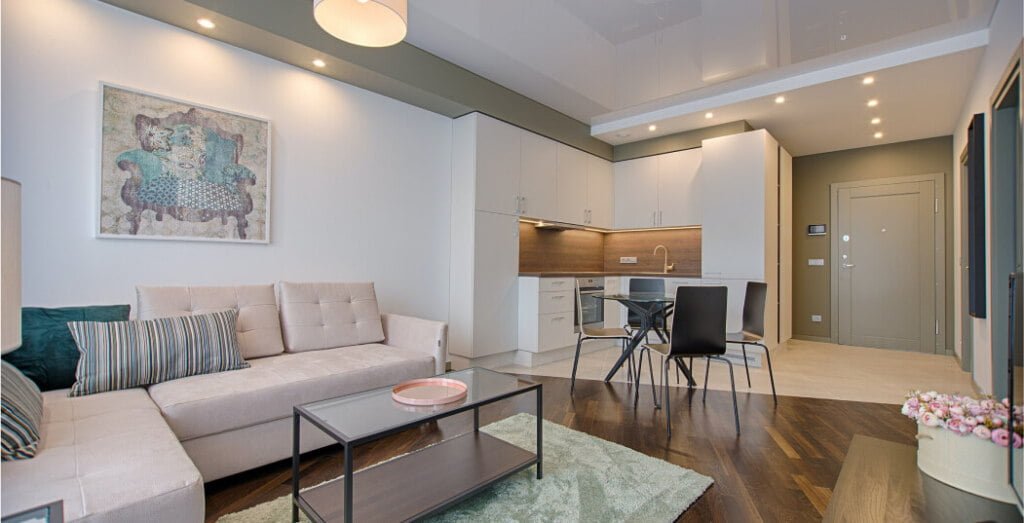 A living room and kitchen area in a modern apartment.