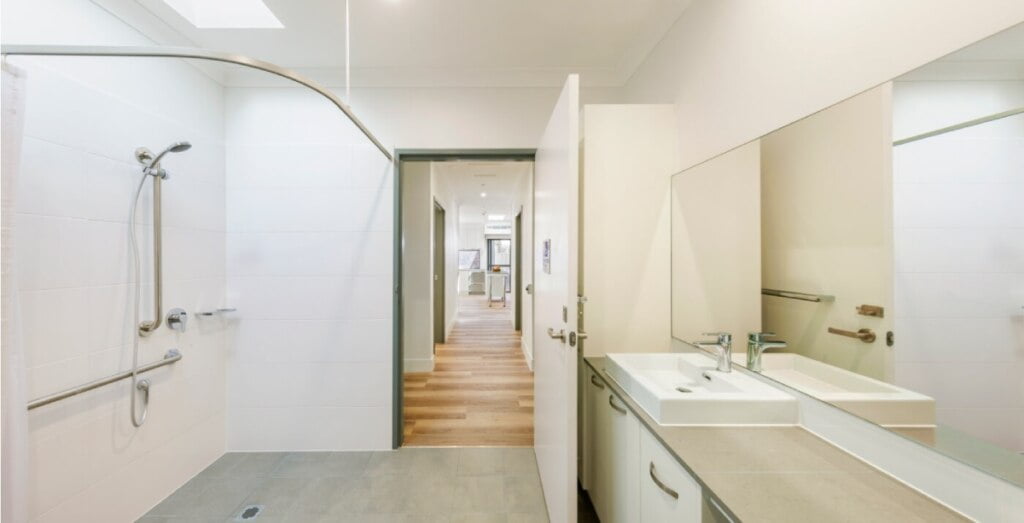 A white bathroom with a walk in shower.