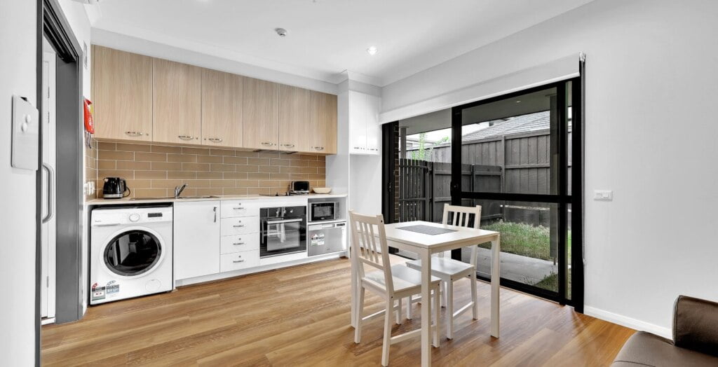 A kitchen with a washing machine and a table.