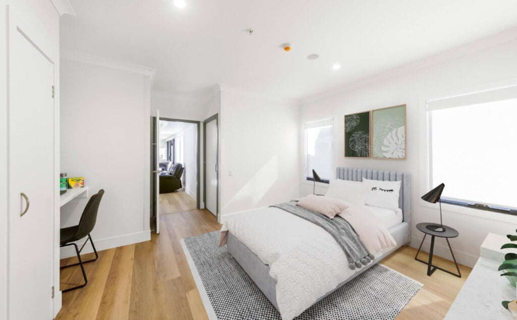 A white bedroom with a bed and a desk.
