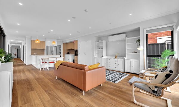 A living room with hardwood floors and a kitchen.