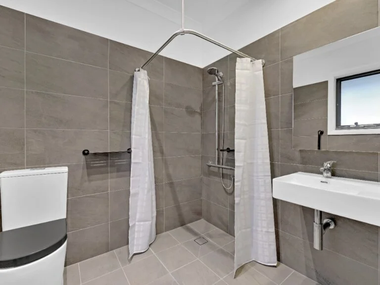 A bathroom with a shower, toilet and sink located in Concord, Inner West, NSW.