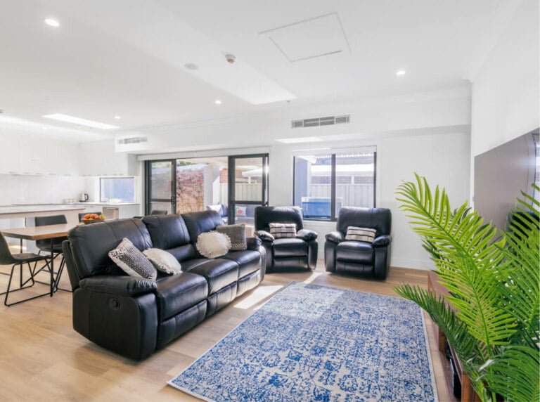 A cozy living room in the Eastern Suburbs of NSW featuring a comfortable couch and a modern TV.