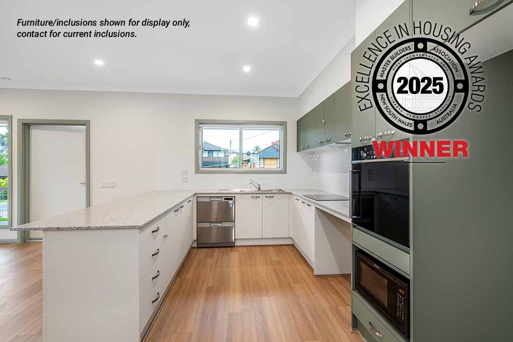 Modern kitchen at 8A Pendle Hill with white and green cabinetry, stainless steel appliances, and wood flooring. A "2025 Excellence in Housing Awards Winner" badge is overlaid in the top right corner.