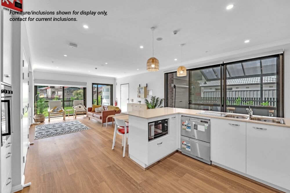 Modern open-plan kitchen and living area at 10A Concord, Inner West Sydney, featuring large windows, wooden flooring, light-colored cabinetry, and minimalistic furniture.