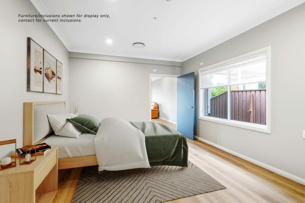A modern bedroom in Pagewood features a bed, wooden nightstand, wall art, and a window with curtains. A door on the right side opens to reveal another room in Inner South Sydney. Text on the wall reads, "Furniture/inclusions shown for display only.