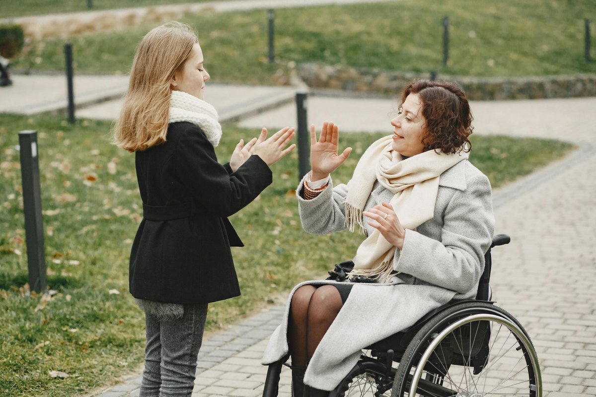 Family enjoying playful outdoor moment with wheelchair user - SDA Concord Burwood Strathfield Inner West
