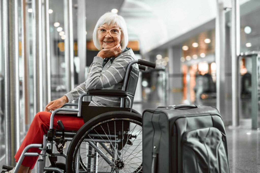 An elderly woman in a wheelchair at an airport, requiring accessible accommodation.